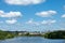 Panoramic waterfront residential complex grassy lawn under cloudy blue sky