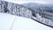 Panoramic winter drone view of the mountains in the forest. Cinematic winter snowy rural asphalt road.