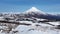 Panoramic winter mountainous landscape: snowy cone of volcano