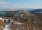 A panoramic winter scene with snow covered pennine hills and trees with a path and gate leading to fields on a bright sunlit day