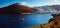 A panoramiv view of a small boat entering the old harbor of Ast