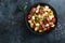 Panzanella, traditional italian tomato, mozzarella and bread salad in black bowl