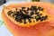 PAPAYA. Exotic tropical fruit of orange color with black seeds.