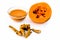 Papaya face mask or ubtan isolated on white i.e. Pieces of ripe papaya and turmeric powder well mixed in a glass bowl and entire i