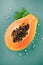 Papaya fruit on blue background with water drops, fresh exotic fruits design. Half of fresh organic ripe Papaya