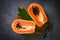 Papaya fruits on dark backgroud, fresh ripe papaya slice cut in half tropical fruit with papaya seed and leaf leaves from papaya