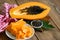 Papaya fruits on wooden backgroud, fresh ripe papaya slice on white plate tropical fruit with papaya seed and leaf leaves from