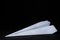 Paper airplane on a black background. Origami paper toy