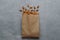 Paper bag with delicious almonds on grey table, top view