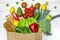 Paper bag of different health food on white wooden background. Top view. Flat lay