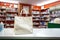 Paper bag on drugstore counter, shelves stocked with health essentials