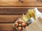 Paper bag with food supplies crisis stock for quarantine isolation period on wooden background. Eggs, milk, canned food, pasta.