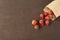 Paper bag with fresh red strawberries. Fresh strawberries in a small bag on a wooden style surface. Small group of strawberries on