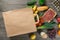 Paper bag full of different groceries on wooden background