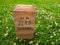 A paper bag with handwritten words `Go to zero waste` on it stands among clover and green grass.