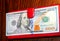 Paper banknote in a hundred dollars of USA dollars and lying nearby phone in red case