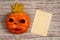 Paper blank, a pumpkin with eyes of chestnuts, lips of red hawthorn berries, a crown of maple leaf on a wooden background