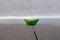 Paper boat on a railing with a background of sky and ocean