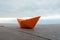 Paper boat on a railing with a background of sky and ocean