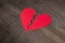 Paper broken heart on dark wooden background