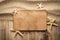 Paper card and starfishes on sand and wooden table