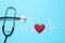 Paper cardiogram line, red heart and stethoscope on light blue background
