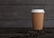 Paper coffee cup with cappuccino and coffee beans