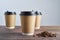 Paper coffee disposable cup for take away or to go, wooden table, space for design mock-up