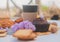 Paper cup with assorted pastries, chocolate muffin and lilac flowers, outdoor