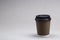 Paper cup with coffee cappuccino on grey background Close up