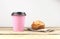 Paper cup of coffee and fresh muffin on wooden table