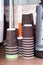 paper cups in stacks near coffee machine on wooden table in cafe