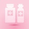 Paper cut Medicine bottle icon isolated on pink background. Bottle pill sign. Pharmacy design. Paper art style. Vector