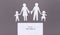 Paper cut out figures of broken family with children on gray