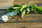 Paper dollar and coins on a wooden background with lily of the valley flower.