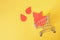 paper drops of blood and shopping trolley on yellow background, world donor day concept