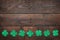 Paper green clover shamrock leaf border on dark wooden background