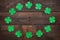 Paper green clover shamrock leaf border frame on dark wooden background
