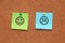 Paper with happy and sad faces on corkboard