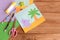 Paper hippo and palm tree applique, colored paper sheets, scissors, pencils, glue, eraser on wooden background with blank space
