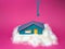 Paper house on top of cotton with cloud effect and a key on a pink background