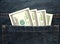 Paper hundred United States dollar bills in the back pocket of jeans