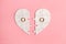 Paper jigsaw puzzle heart split in two pieces with golden wedding rings, top view, flat lay