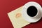 Paper napkin with a kiss and coffee cup on red background