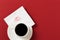 Paper napkin with a kiss and coffee cup on red background