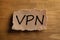 Paper note with acronym VPN on wooden table