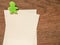 Paper note with green clip on wood background