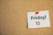 Paper note with phrase Friday! 13 pinned to cork background. Bad luck superstition