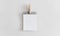 Paper note and wooden paper clip hanging on white wall