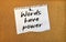 Paper note written with WORDS HAVE POWER inscription on cork board